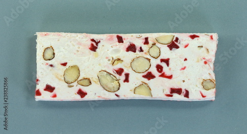 French soft nougat with strawberry flawour and almonds isolated on white background. Greek manolato. photo