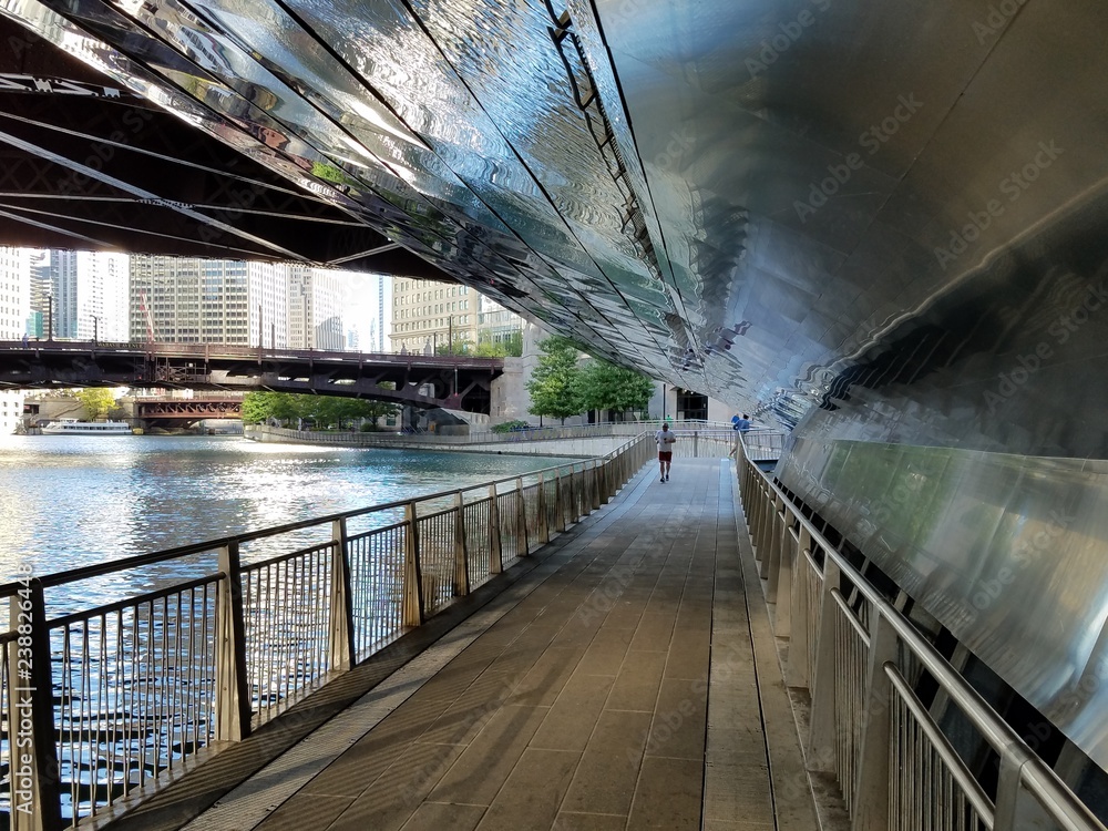 Obraz premium Chicago, Illinois 10-08-2016 Reflective curved metal walls and ceilings of the Chicago Riverwalk underpasses beneath the bridges crossing the river.