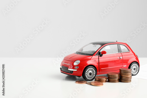 Toy car and money on white background, space for text. Vehicle insurance