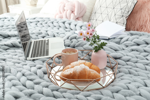 Dienblad met lekker ontbijt, laptop en boek op bed