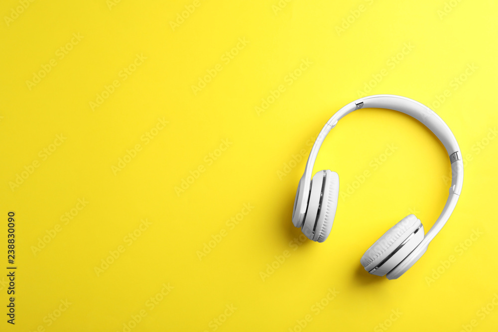 Wireless headphones on color background, top view. Space for text Wireless headphones on color background, top view. Space for text