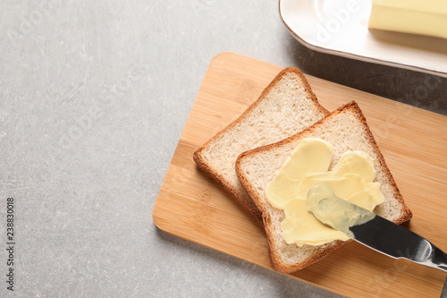 Tasty toast with butter and knife on table, top view. Space for text