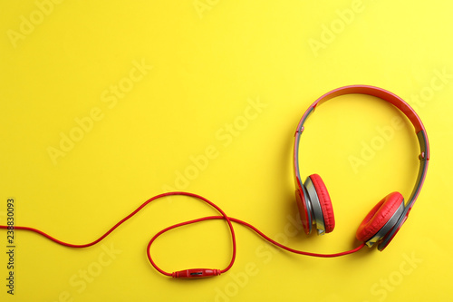 Stylish headphones on color background, top view. Space for text