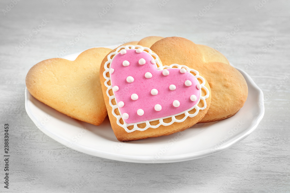Plate with decorated heart shaped cookies on wooden table Plate with decorated heart shaped cookies on wooden table
