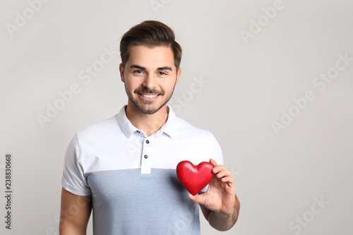 Portrait of young man with decorative heart on light background. Space for text © New Africa