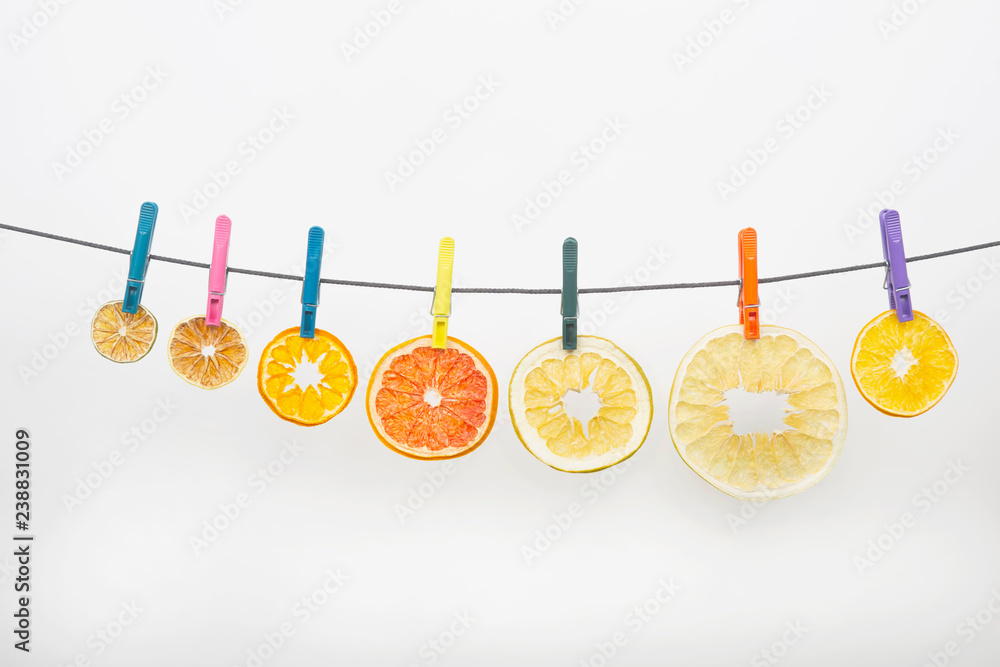 dried pieces of citrus fruits hang on clothespins on white background dried pieces of citrus fruits hang on clothespins on white background