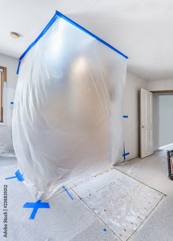 Taped plastic sheeting protects a stairwell during the demolition phase of a home remodel Stock