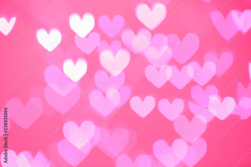Blurred view of beautiful heart shaped lights on color background