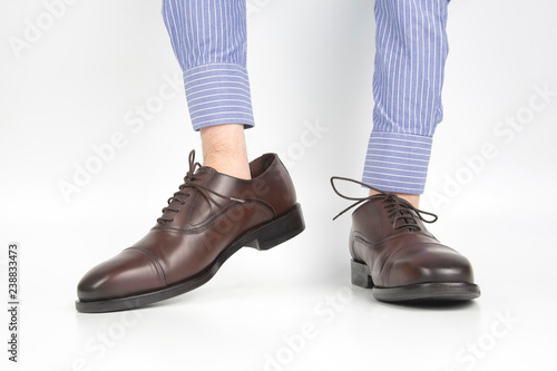 Classic brown shoes worn on the hands on a white background