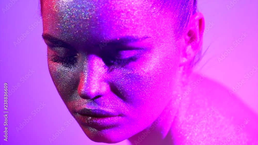 Fashion model woman in colorful bright sparkles and neon lights posing in studio, portrait of beautiful sexy girl. Art design colorful vivid makeup. Slow motion 4K UHD video footage. 3840X2160 Fashion model woman in colorful bright sparkles and neon lights posing in studio, portrait of beautiful sexy girl. Art design colorful vivid makeup. Slow motion 4K UHD video footage. 3840X2160