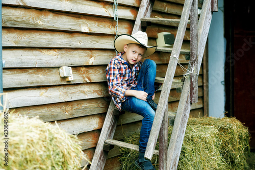 portrait of a boy in a hat on a ranch