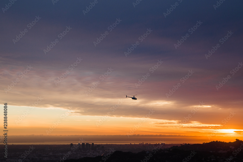helicopter flying at sunset above the Hollywood Hills in Los Angeles