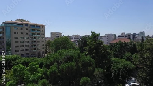 Rising drone shot beginning on beautiful green trees and revealing the picturesque city of Nicosia Cyprus photo