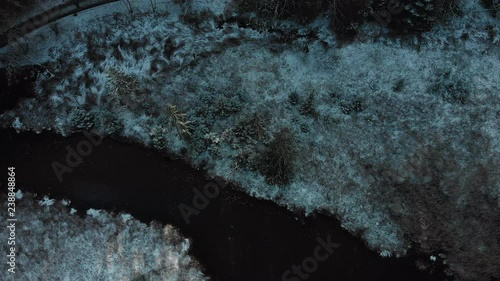 Aerial, drone shot, above a river and first snow, on frozen ground, on a cloudy winter day, at Hackensee, in Bavaria near Holzkirchen photo