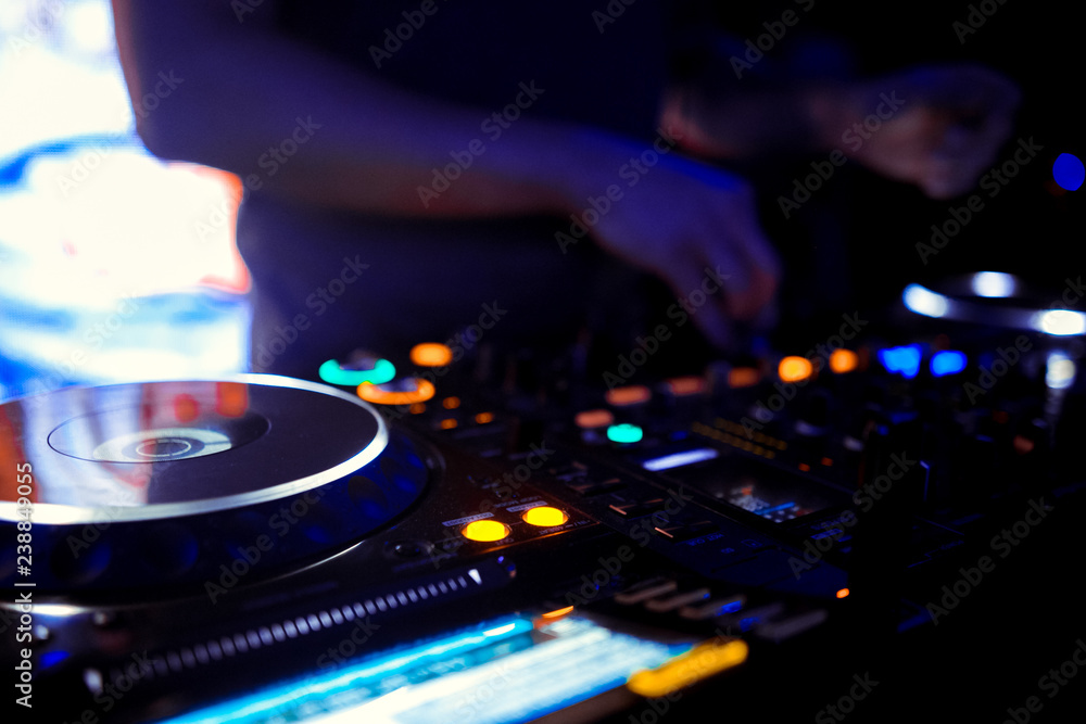 Naklejka premium Dj mixes the track in the nightclub at party
