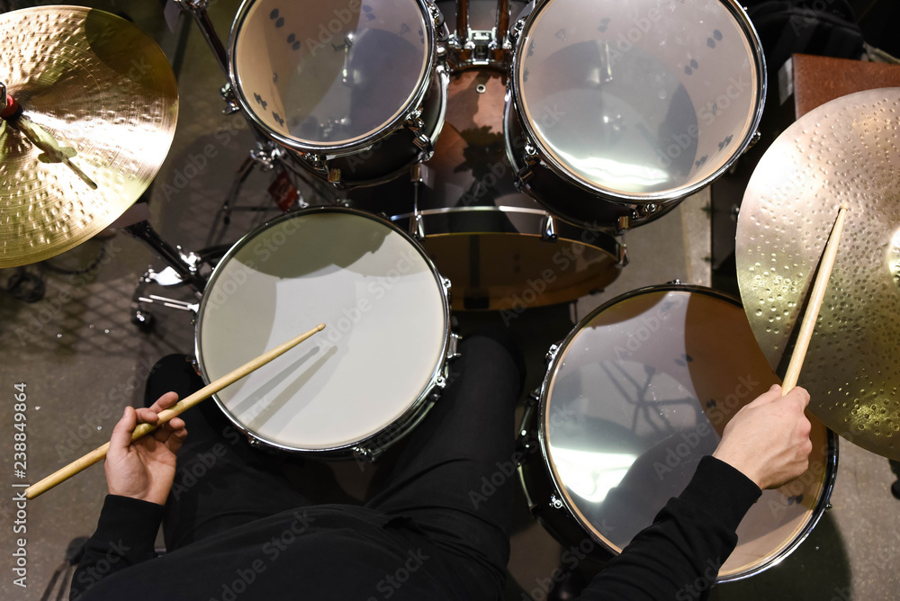 Professional drum set closeup. Man drummer with drumsticks playing drums and cymbals, on the live music rock concert or in recording studio Professional drum set closeup. Man drummer with drumsticks playing drums and cymbals, on the live music rock concert or in recording studio