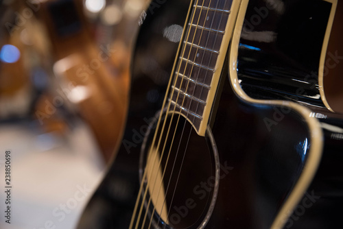 Closeup of row of different colorful guitars on the display for sale hanging in a music shop 