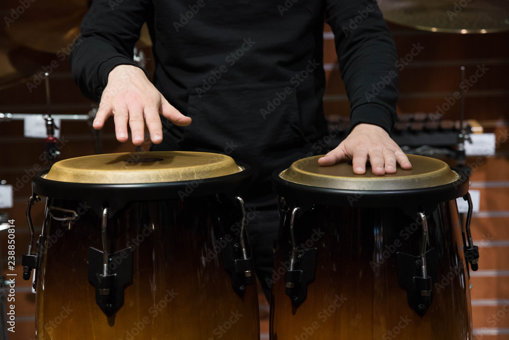 Obraz premium Professional percussion drum set closeup. Man drummer playing kongo percussion drums on the live music rock concert or in recording studio 