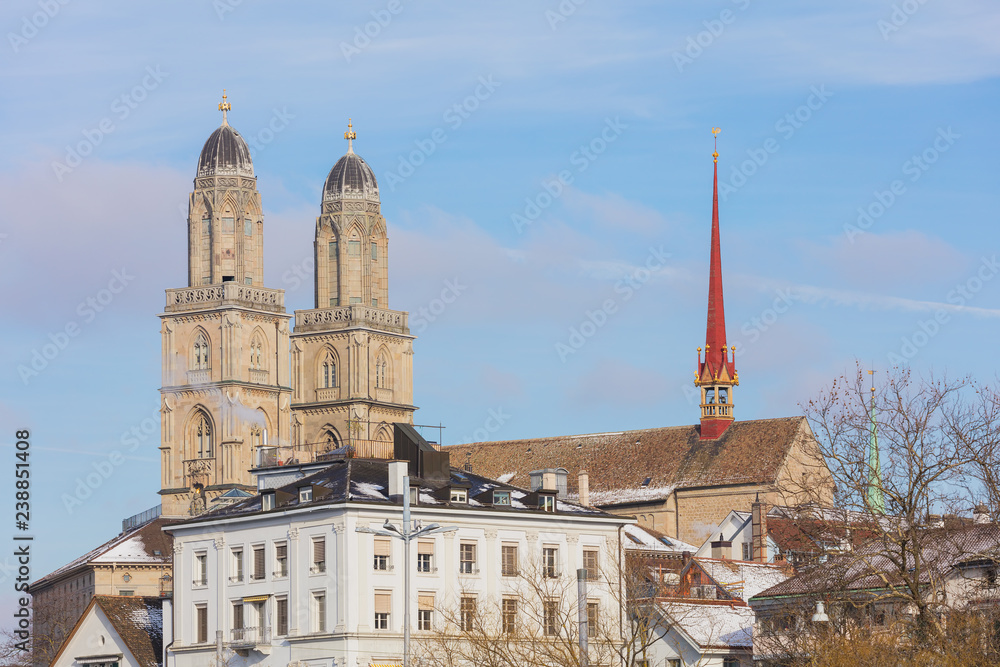 Buildings of the historic part of the city of Zurich along the Limmat river in winter, towers of the famous Grossmunster cathedral above them