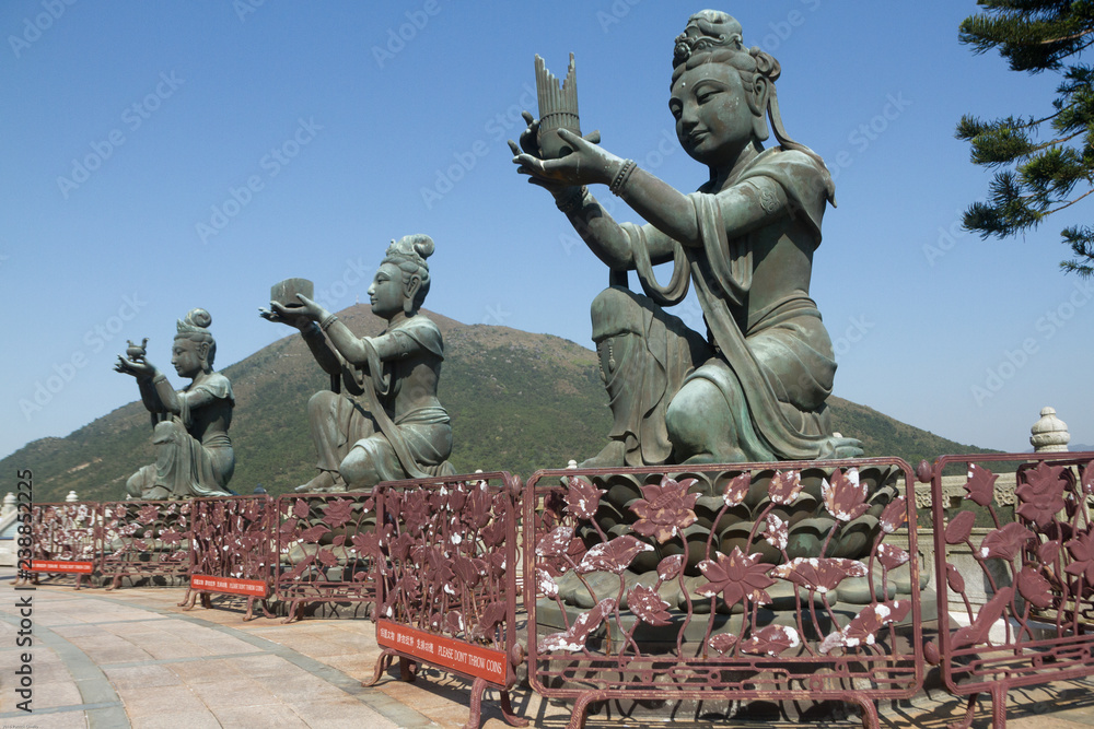 Color, daytime landscape photo of three bodhisattva sculptures at the Po Lin Monastery, Lantau Island, Hong Kong, China. 