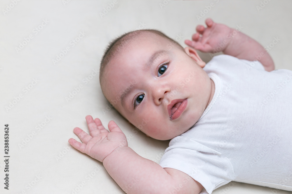 infant boy is lying in a baby crib infant boy is lying in a baby crib