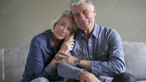 Loving senior couple smiling together on couch