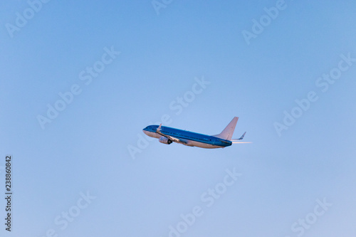 blue passenger plane taking off in the sky