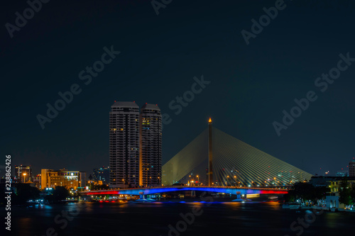 The Beauty Of The Chao Phraya River And Boat At Night With Rationalism At Pinklao Bridge ,bangkok in Thailand.