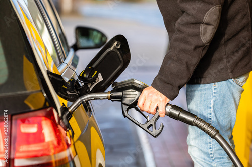 Hand with fuel nozzle at a gas station