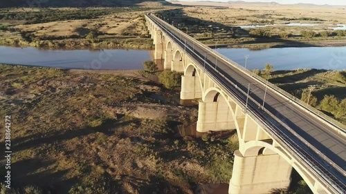 Reverse flight following arched Bridge over River in Africa