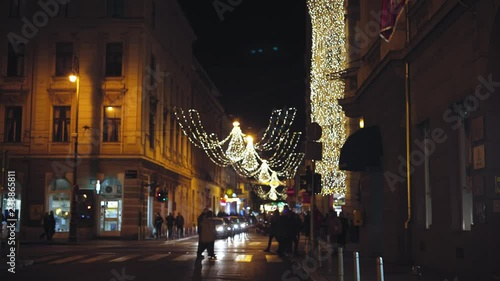 The beautiful holidays decoration and people walking by the Josipa Jurja Strossmayera Park during Advent time. Zagreb Croatia. Flat plane photo