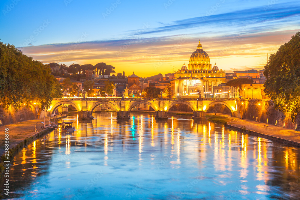 Cityscape of Rome at twilight with San Pietro cathedral, Sant'Angelo bridge and Tevere river illuminated by city lights of Roma in Italy