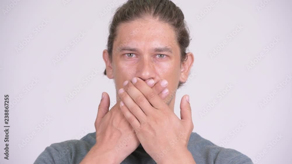 Handsome man covering mouth as three wise monkeys concept Handsome man covering mouth as three wise monkeys concept