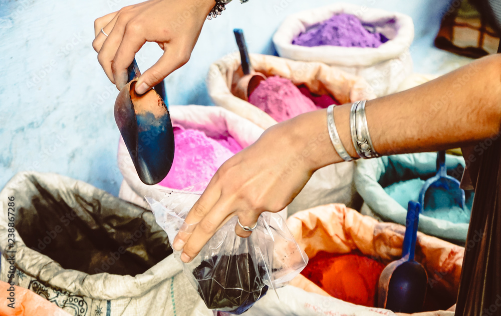 Obraz premium Young tourist buying coloured pigments as souvenir in Chefchaouen