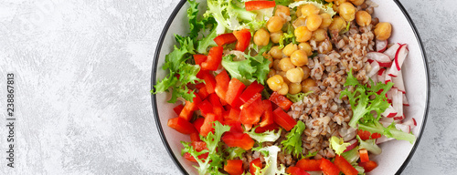 Healthy and delicious bowl with buckwheat and salad of chickpea, fresh pepper and lettuce leaves. Dietary balanced plant-based food. Vegan and vegetarian dish. Top view. Flat lay. Banner
