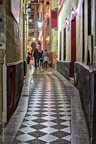 Narrow street in old town Seville, Spain, at night.