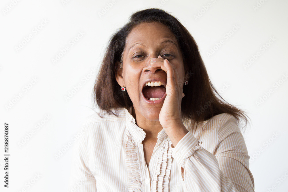 Excited mix raced lady sharing urgent news. Joyful mid adult woman shouting loud with hand at mouth. Announcing concept Excited mix raced lady sharing urgent news. Joyful mid adult woman shouting loud with hand at mouth. Announcing concept