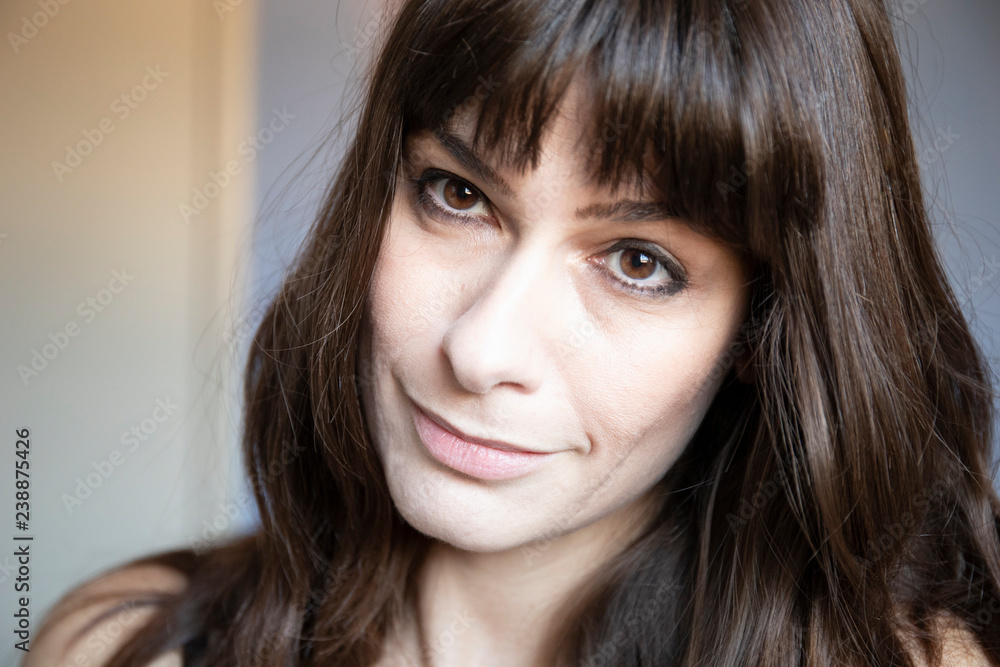 Young woman close-up portrait. Caucasian with brown long hair and bangs. Young woman close-up portrait. Caucasian with brown long hair and bangs.