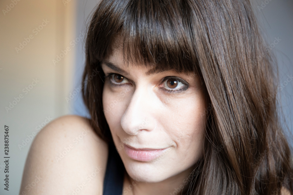 Young woman close-up 3/4 portrait. Caucasian with brown long hair and bangs. Young woman close-up 3/4 portrait. Caucasian with brown long hair and bangs.