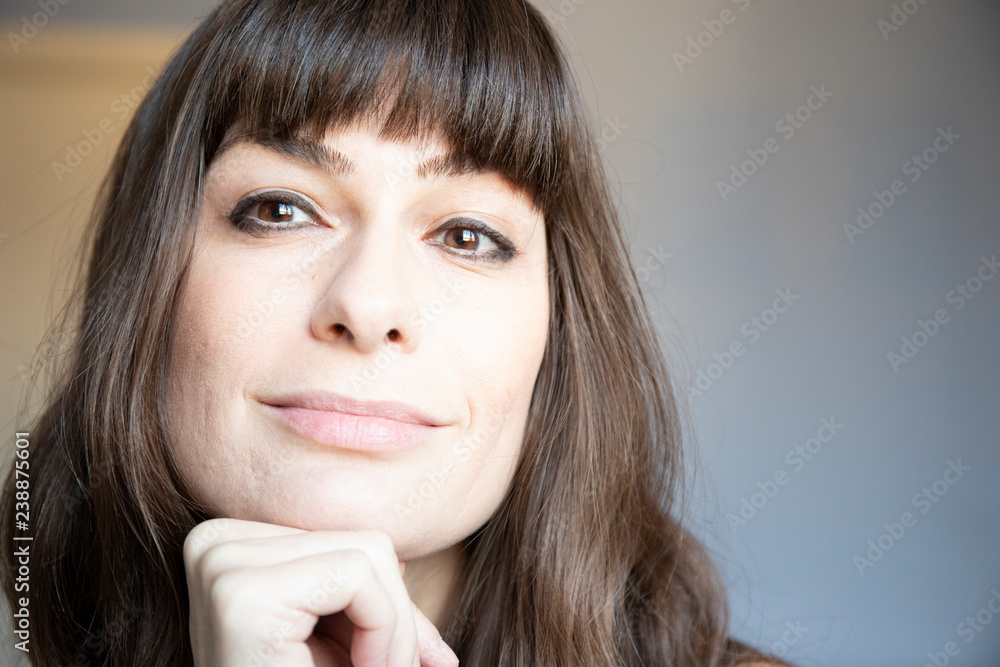 Young woman close-up portrait. Caucasian with brown long hair and bangs. Young woman close-up portrait. Caucasian with brown long hair and bangs.