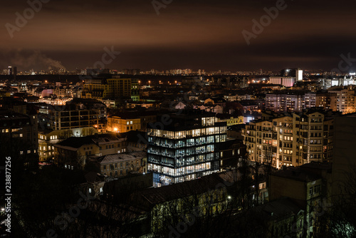 cityscape with bright illumination in windows of buildings