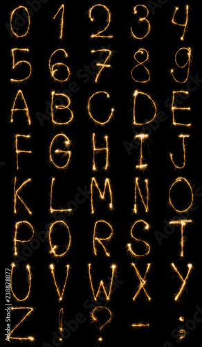 close up view of light english alphabet and numbers on black background
