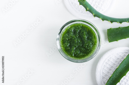Small glass bowl with aloe vera puree. Homemade facial or hair mask (moisturizer). Natural beauty treaments and spa. White background. Top view, copy space.   