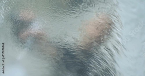 A young professional guy (male) window cleaner uses foam and detergents for windows and various accessories, then wipes them thoroughly. Concept of: Glitter windows, Detergents.