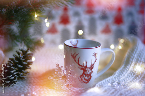 Cup with a deer on the background of the lights of Christmas garland
