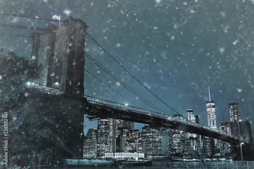 Toned photo of skyscrapers of Manhattan and Brooklyn bridge at snowy winter night