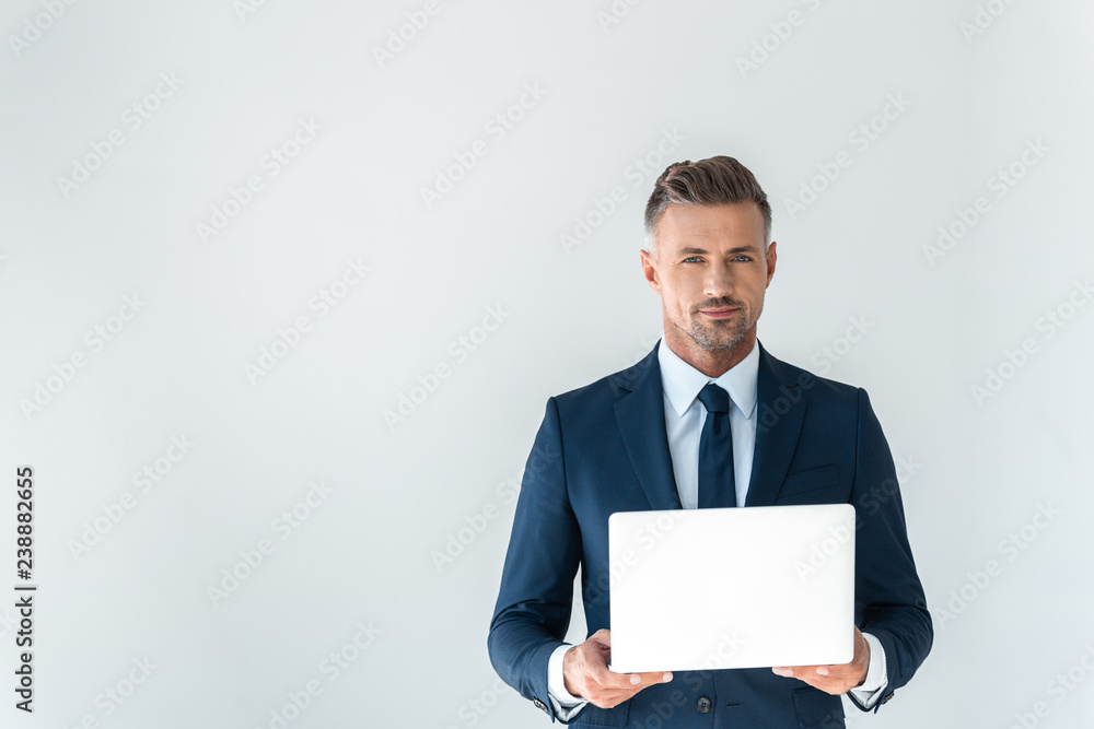 handsome businessman holding laptop and looking at camera isolated on white handsome businessman holding laptop and looking at camera isolated on white