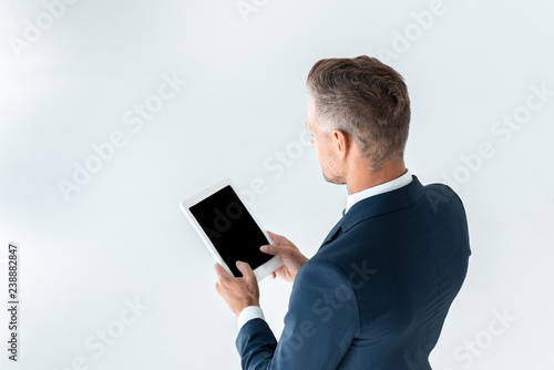 high angle view of businessman holding tablet with blank screen isolated on white