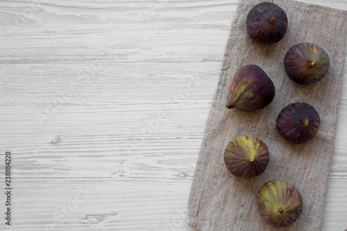 Fresh figs on cloth on a white wooden surface, top view. Flat lay, overhead, from above.