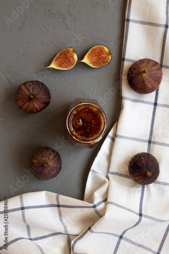 Fig jam in glass jar and fresh figs on grey background, overhead view. Flat lay, from above, top view.
